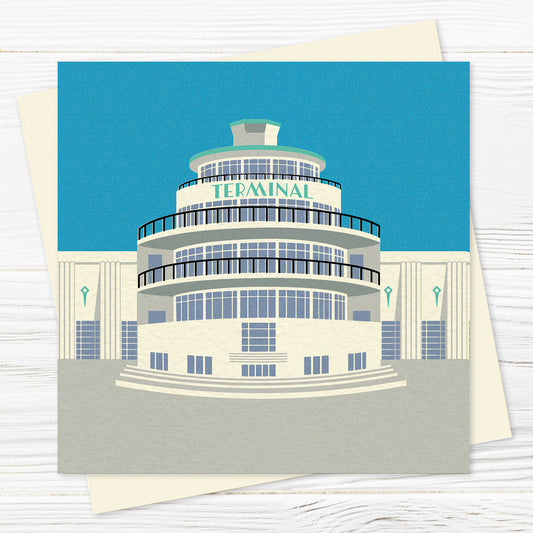 A  greetings card and envelope featuring a stylised illustration of an circular art deco airport building in blue, grey and green with the word 'terminal' across the front of the building.